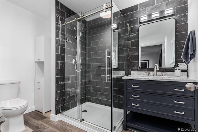 bathroom with vanity, hardwood / wood-style flooring, toilet, and walk in shower