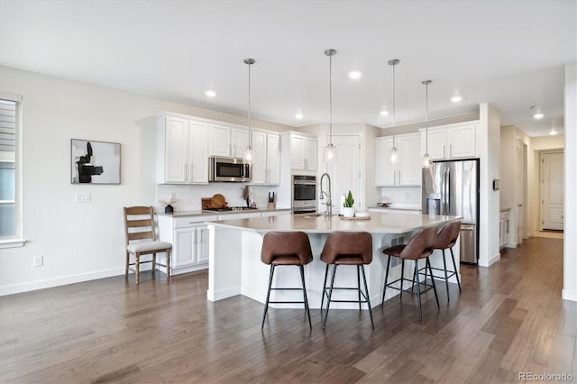 kitchen featuring a large island, white cabinetry, stainless steel appliances, and decorative light fixtures