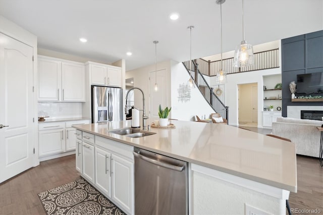 kitchen featuring white cabinets, stainless steel appliances, and a kitchen island with sink