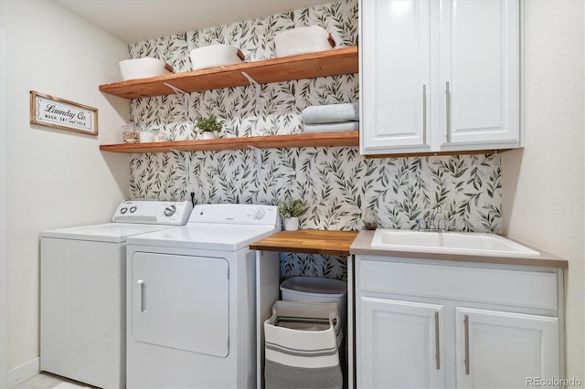 washroom featuring cabinets, sink, and washing machine and clothes dryer