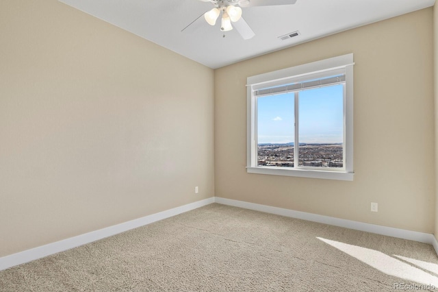 carpeted spare room featuring ceiling fan