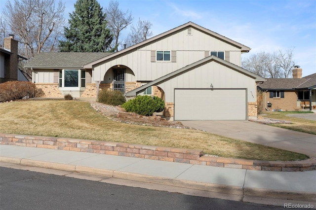 3765 S Depew St, Denver, CO 80235 - view of front of house featuring driveway, brick siding, a front lawn, and board and batten siding