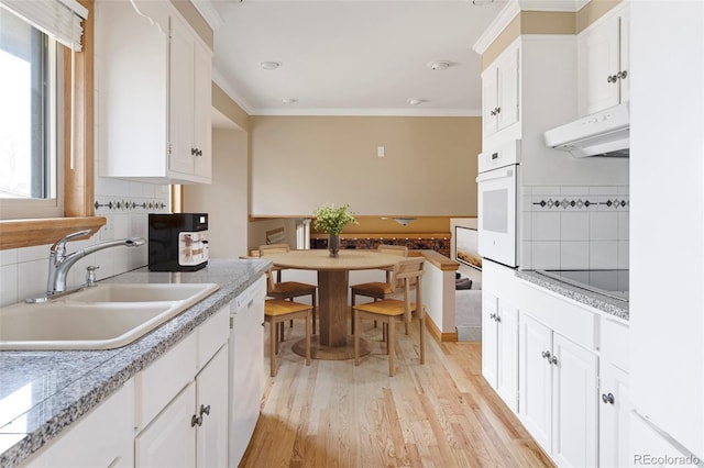 3765 S Depew St, Denver, CO 80235 - kitchen featuring light wood finished floors, a sink, extractor fan, crown molding, and white appliances