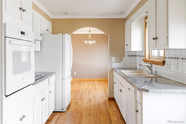 3765 S Depew St, Denver, CO 80235 - kitchen with white appliances, light wood finished floors, a sink, decorative backsplash, and arched walkways