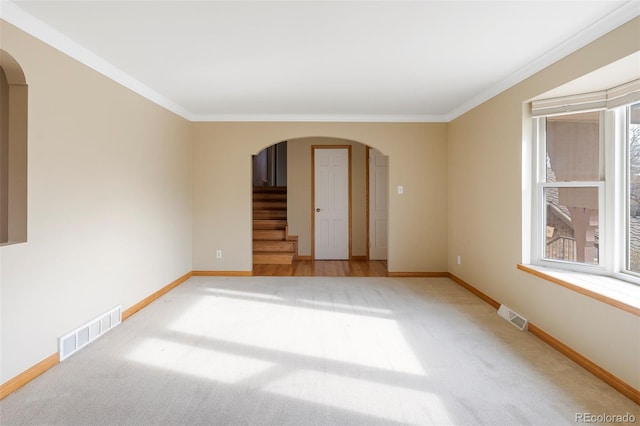 3765 S Depew St, Denver, CO 80235 - empty room featuring light colored carpet, visible vents, arched walkways, and stairway
