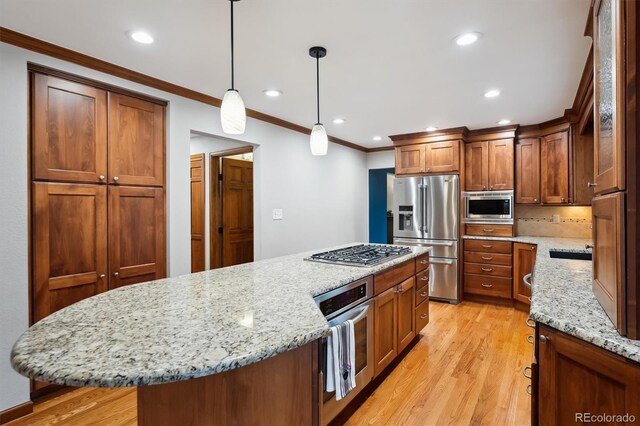 1998 S Harlan Ct, Lakewood, CO 80227 - kitchen with appliances with stainless steel finishes, a kitchen island, crown molding, light wood-style floors, and light stone counters