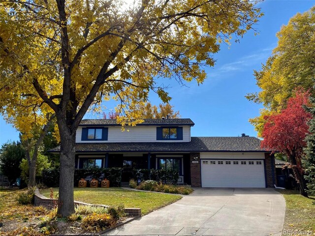 1998 S Harlan Ct, Lakewood, CO 80227 - traditional-style home with an attached garage, driveway, a front yard, and brick siding