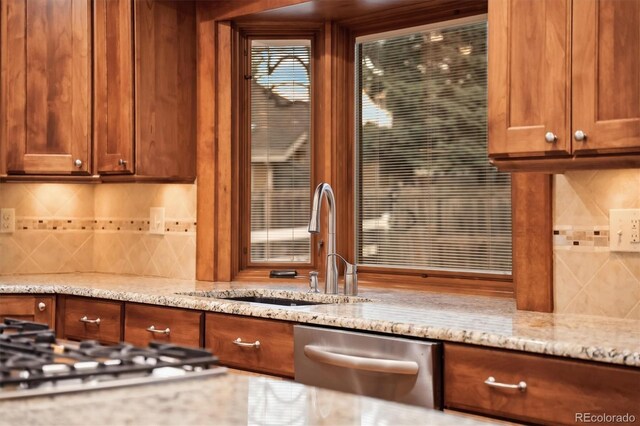 1998 S Harlan Ct, Lakewood, CO 80227 - kitchen with dishwasher, a sink, gas cooktop, light stone counters, and decorative backsplash