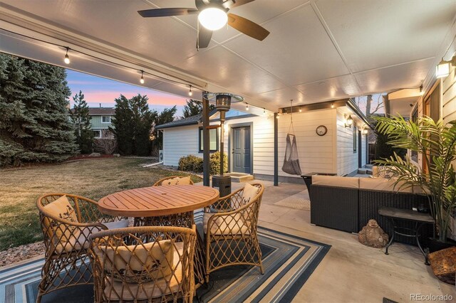 1998 S Harlan Ct, Lakewood, CO 80227 - patio terrace at dusk with a patio, an outdoor hangout area, ceiling fan, a yard, and outdoor dining space