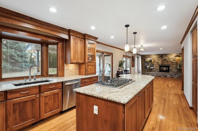 1998 S Harlan Ct, Lakewood, CO 80227 - kitchen featuring stainless steel appliances, a sink, light wood finished floors, light stone counters, and ornamental molding