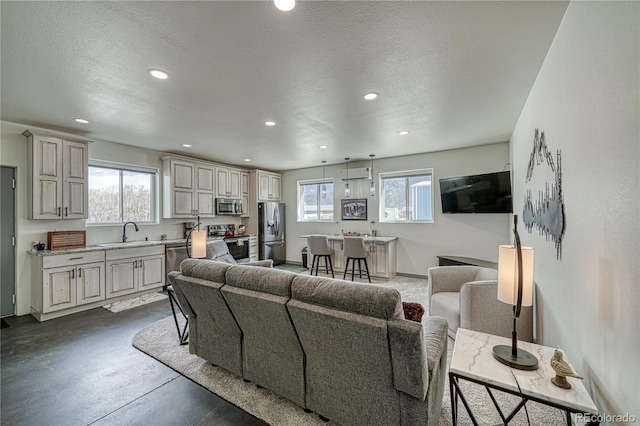 living room with concrete flooring, a textured ceiling, and sink