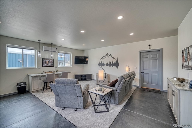 living room with a wall unit AC, concrete floors, and a textured ceiling