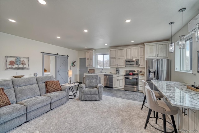 carpeted living room featuring a barn door and sink