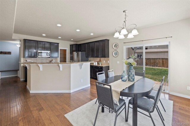 10414 Declaration Dr, Colorado Springs, CO 80925 - dining space with a chandelier, recessed lighting, and wood finished floors