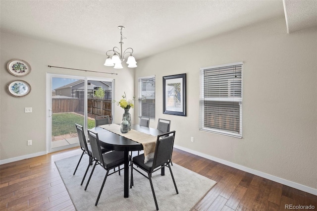 10414 Declaration Dr, Colorado Springs, CO 80925 - dining space with a chandelier, wood-type flooring, and a textured ceiling