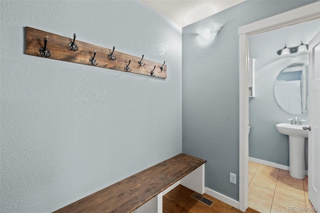 10414 Declaration Dr, Colorado Springs, CO 80925 - mudroom featuring a textured wall and a sink