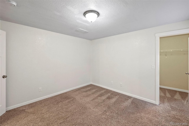 10414 Declaration Dr, Colorado Springs, CO 80925 - unfurnished bedroom featuring carpet flooring, a textured ceiling, and a spacious closet