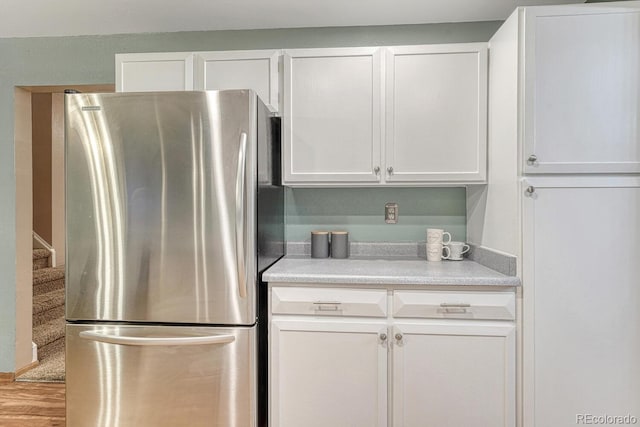 15918 E Flora Pl, Aurora, CO 80013 - kitchen featuring freestanding refrigerator, white cabinets, light countertops, and wood finished floors