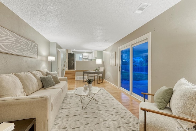 15918 E Flora Pl, Aurora, CO 80013 - living area featuring light wood-style floors, a textured ceiling, and a textured wall