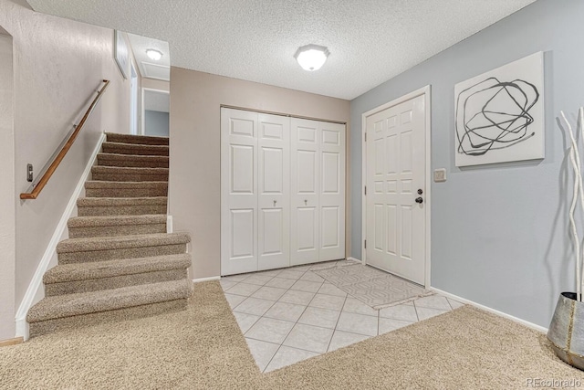 15918 E Flora Pl, Aurora, CO 80013 - entrance foyer featuring baseboards, stairway, light tile patterned flooring, and a textured ceiling