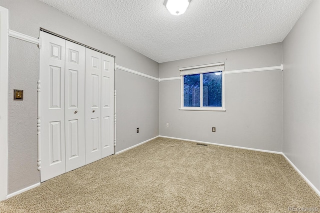 15918 E Flora Pl, Aurora, CO 80013 - unfurnished bedroom with a textured ceiling, carpet flooring, a closet, and baseboards