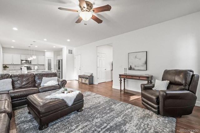 living room with a ceiling fan, dark wood-type flooring, recessed lighting, and baseboards