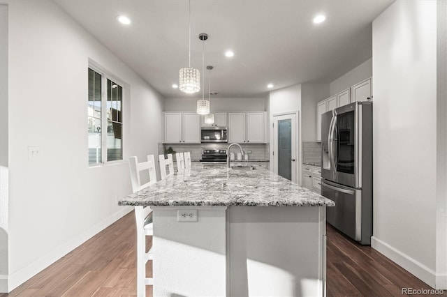 kitchen with appliances with stainless steel finishes, baseboards, dark wood finished floors, recessed lighting, and decorative backsplash
