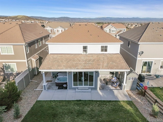 rear view of house featuring a patio area, a mountain view, and a residential view