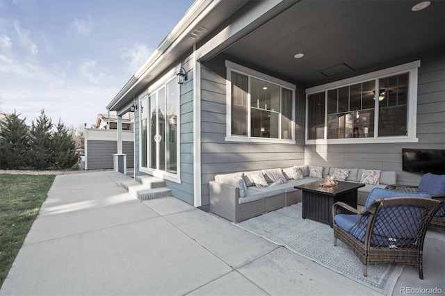 view of patio with an outdoor living space with a fire pit