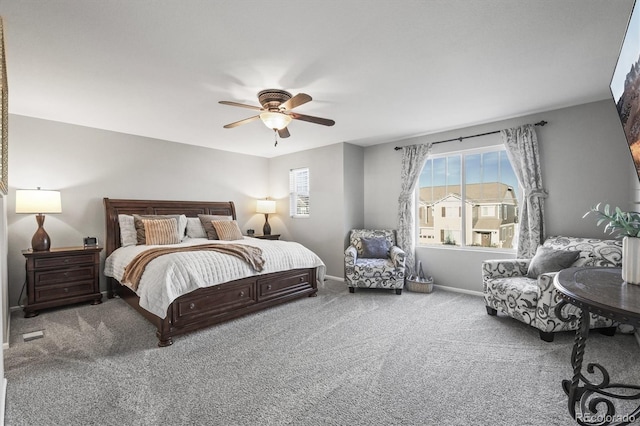 carpeted bedroom featuring multiple windows, ceiling fan, and baseboards