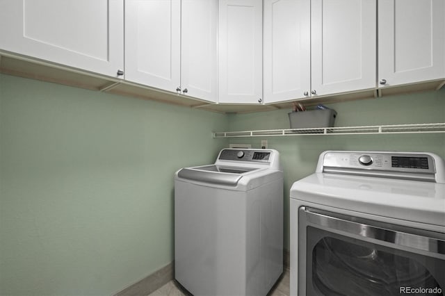laundry area featuring cabinet space, washing machine and clothes dryer, and baseboards