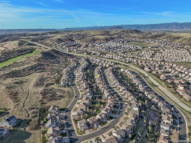 aerial view of property and surrounding area featuring nearby suburban area and a mountainous background