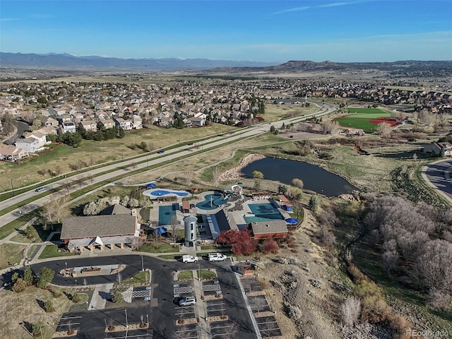 aerial view of property and surrounding area with a water and mountain view and nearby suburban area