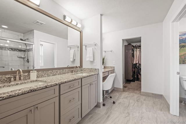 2198 Broadleaf Loop, Castle Rock, CO 80109 - bathroom with double vanity, a stall shower, toilet, a walk in closet, and marble look tiles