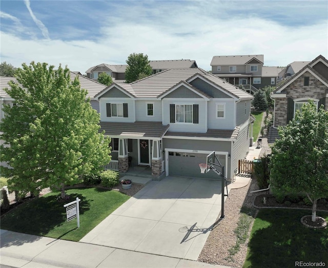 2198 Broadleaf Loop, Castle Rock, CO 80109 - view of front of property featuring concrete driveway, stone siding, a garage, a tiled roof, and a residential view