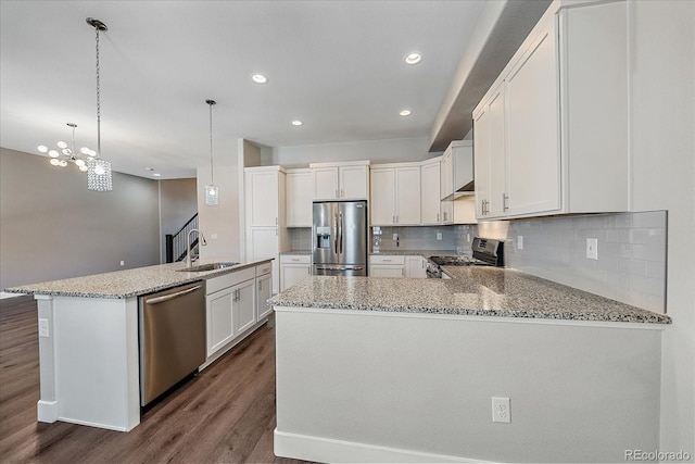 kitchen with sink, hanging light fixtures, white cabinets, and appliances with stainless steel finishes