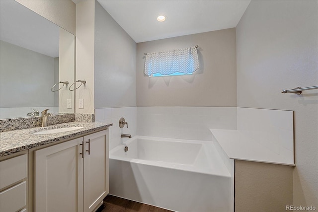 bathroom with vanity, a bathtub, and wood-type flooring