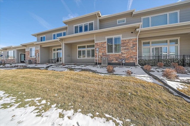 view of front of property featuring central AC unit and a lawn