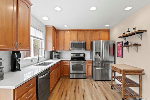 4426 Crow Creek Dr, Colorado Springs, CO 80922 - kitchen featuring stainless steel appliances, a sink, light wood-type flooring, light countertops, and tasteful backsplash