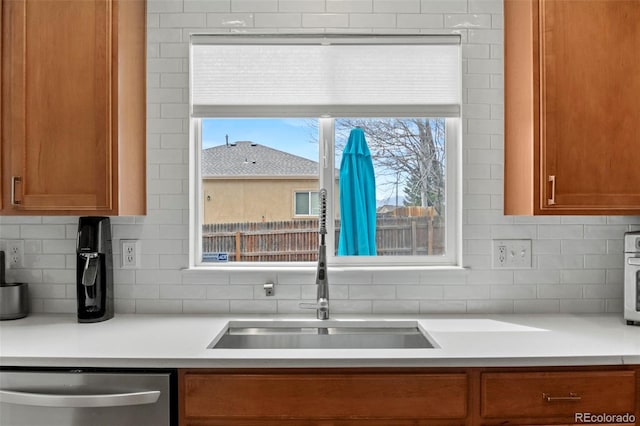 4426 Crow Creek Dr, Colorado Springs, CO 80922 - kitchen with stainless steel dishwasher, tasteful backsplash, brown cabinetry, and light countertops