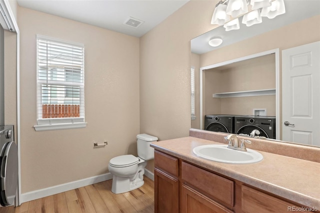 4426 Crow Creek Dr, Colorado Springs, CO 80922 - bathroom featuring baseboards, washer and clothes dryer, wood finished floors, toilet, and vanity