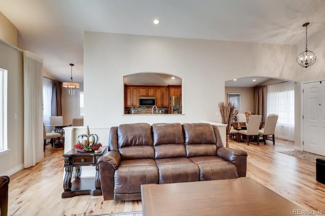 living room featuring light hardwood / wood-style floors, a notable chandelier, and sink