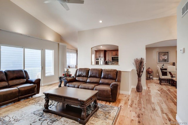 living room with ceiling fan, light hardwood / wood-style floors, and high vaulted ceiling