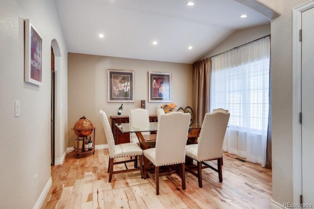 dining area with light wood-type flooring and lofted ceiling