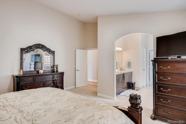 carpeted bedroom featuring ensuite bathroom and vaulted ceiling