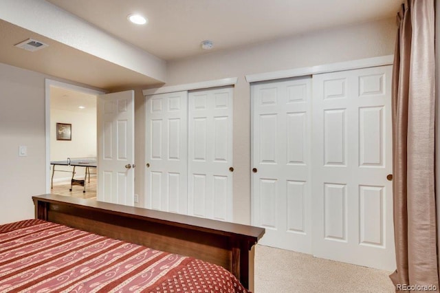 carpeted bedroom featuring multiple closets