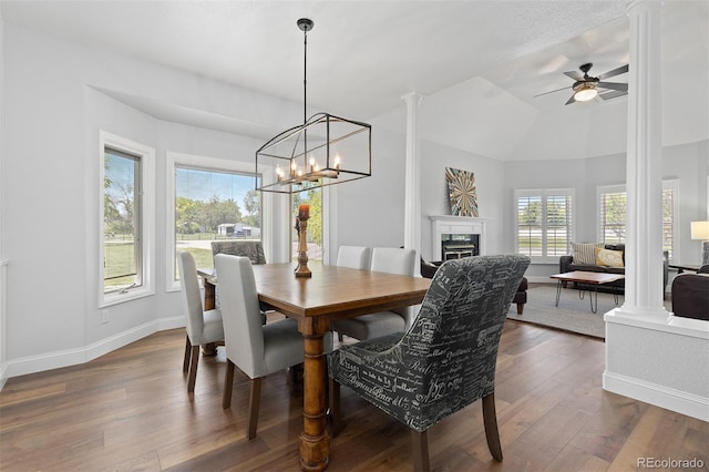 2370 W 152nd Ave, Broomfield, CO 80023 - dining space with decorative columns, dark wood finished floors, a fireplace, a ceiling fan, and a chandelier