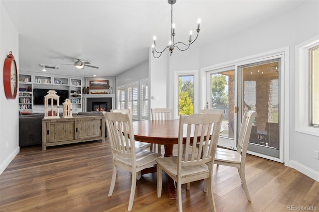 2370 W 152nd Ave, Broomfield, CO 80023 - dining space featuring ceiling fan, wood finished floors, a lit fireplace, and a chandelier