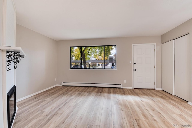 unfurnished living room featuring light hardwood / wood-style floors and a baseboard heating unit