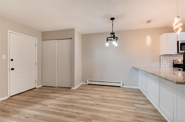 interior space with baseboard heating, appliances with stainless steel finishes, white cabinets, and light hardwood / wood-style flooring